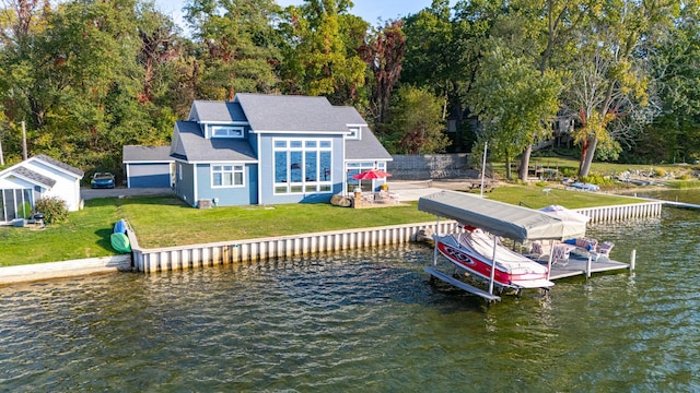 dock area featuring boat lift, a water view, and a lawn