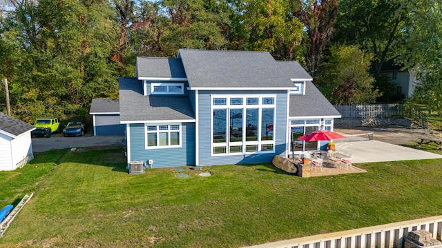 back of property featuring fence, central AC unit, a shingled roof, and a patio area