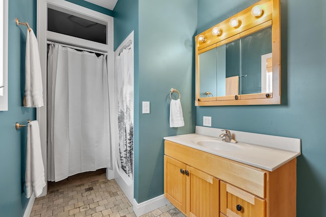 bathroom featuring baseboards, a shower with curtain, and vanity