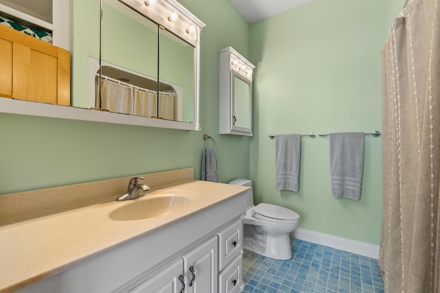 bathroom featuring tile patterned flooring, toilet, vanity, and baseboards