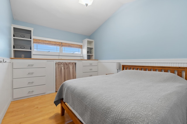 bedroom featuring lofted ceiling and light wood-style floors