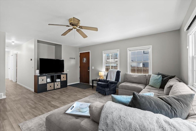 living room featuring a ceiling fan, wood finished floors, and baseboards