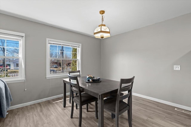 dining area featuring visible vents, baseboards, and light wood-style flooring