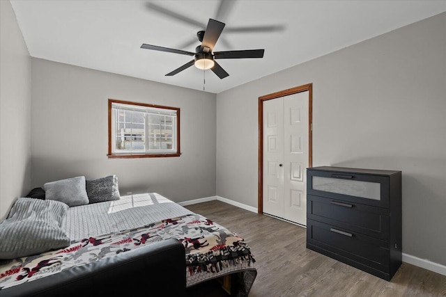 bedroom with baseboards, wood finished floors, and a ceiling fan