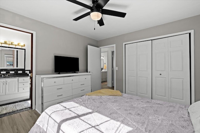 bedroom with a sink, a closet, wood finished floors, and ceiling fan