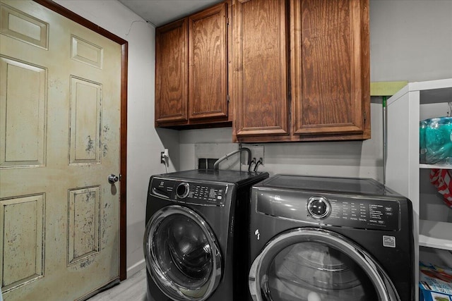 washroom with cabinet space and separate washer and dryer