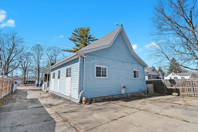 back of house with concrete driveway and fence