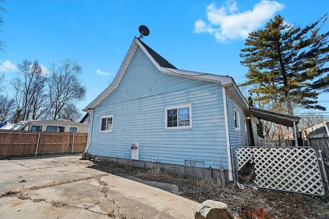 view of property exterior with a patio and fence