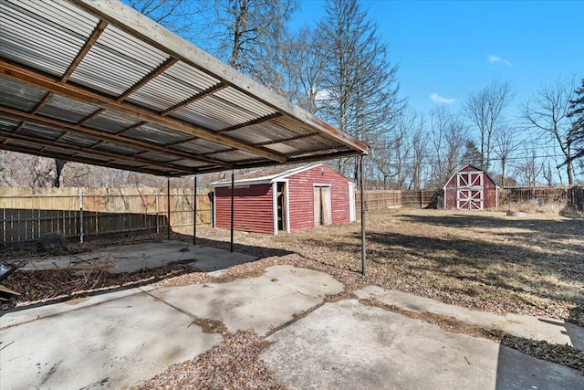 view of parking / parking lot featuring a fenced backyard and a shed