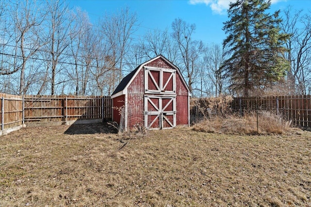 view of barn with a fenced backyard and a lawn