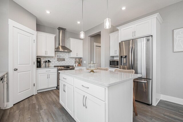 kitchen featuring backsplash, a kitchen island, wall chimney range hood, dark wood-style floors, and stainless steel appliances