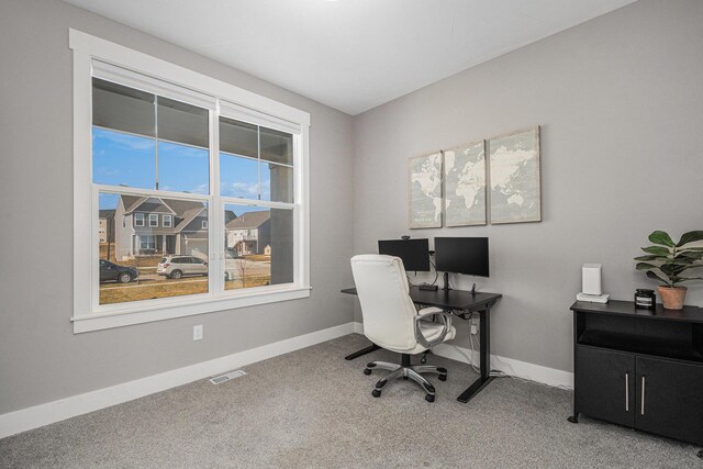 office space with carpet flooring, baseboards, and visible vents