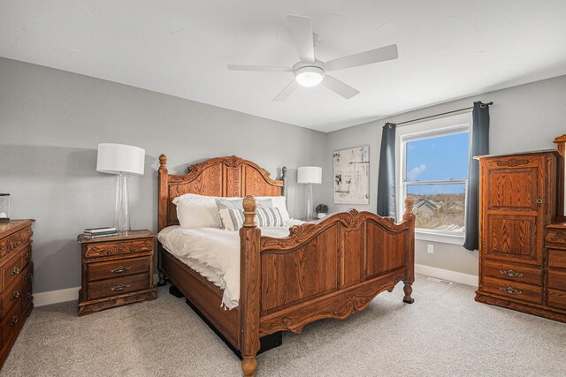 bedroom featuring visible vents, baseboards, light colored carpet, and a ceiling fan