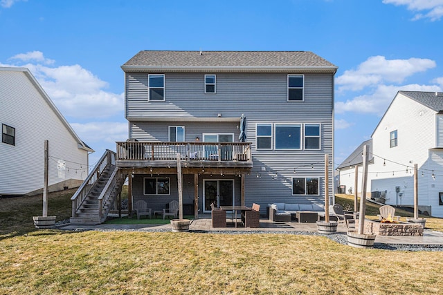 rear view of property featuring a deck, a lawn, stairs, and a patio