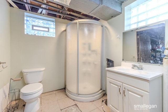 bathroom featuring vanity, toilet, a stall shower, and tile patterned flooring