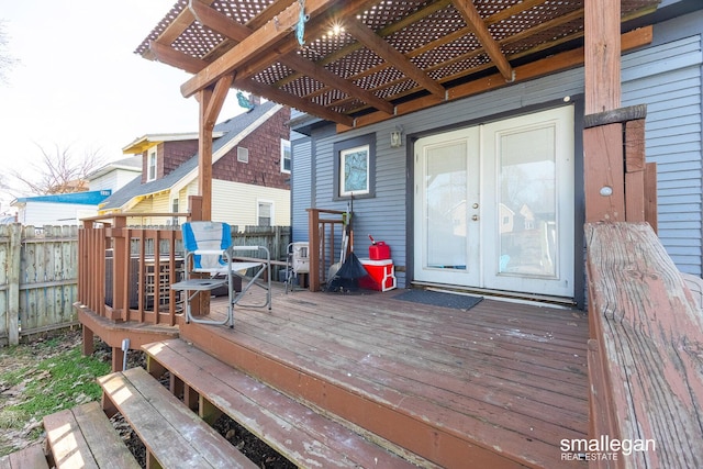 wooden terrace featuring fence, a pergola, and french doors