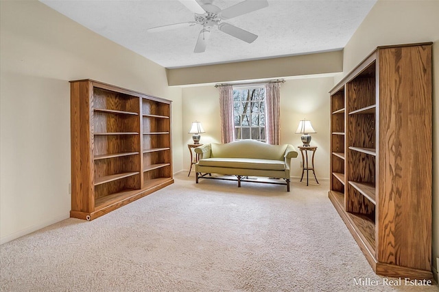 sitting room featuring baseboards, a textured ceiling, ceiling fan, and carpet floors