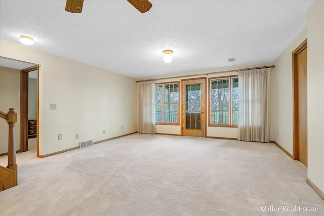 spare room with visible vents, baseboards, a textured ceiling, and ceiling fan