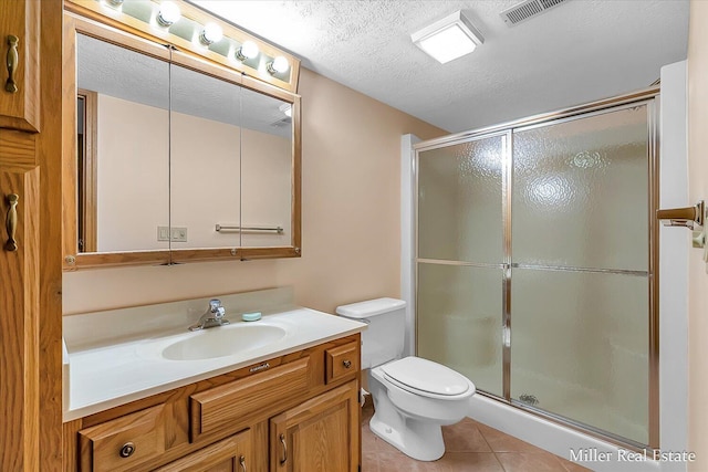 bathroom featuring tile patterned flooring, toilet, a stall shower, and a textured ceiling