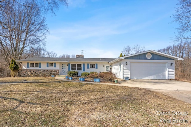 single story home featuring concrete driveway, a front yard, a chimney, a garage, and stone siding