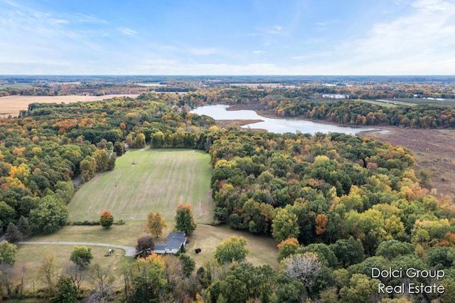 drone / aerial view with a wooded view and a water view