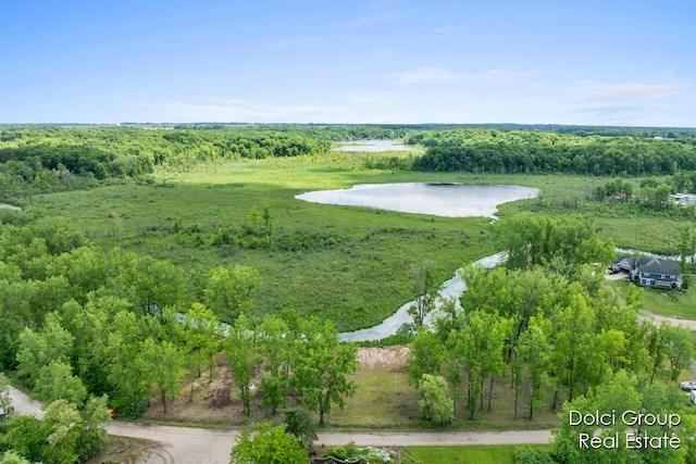 drone / aerial view with a forest view and a water view