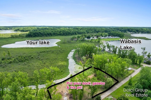 aerial view featuring a forest view and a water view