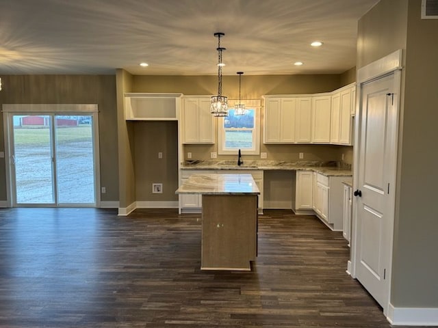 kitchen with an inviting chandelier, a center island, dark wood-style flooring, and a sink