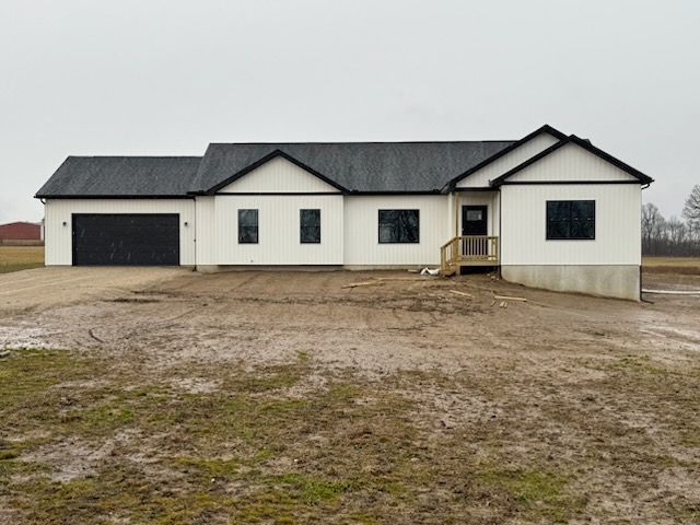 view of front of home featuring a garage and dirt driveway