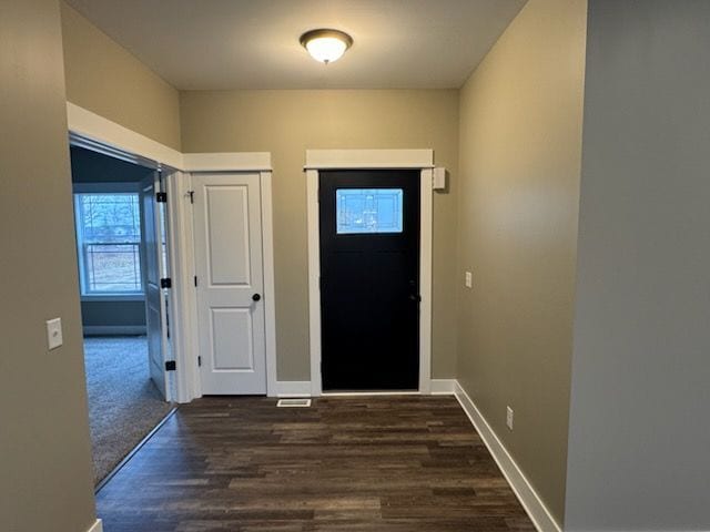 entryway featuring baseboards and dark wood finished floors