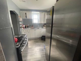 kitchen with white cabinets, appliances with stainless steel finishes, light countertops, and a sink