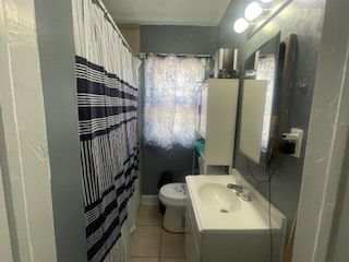 full bathroom with tile patterned flooring, toilet, vanity, and a shower with shower curtain