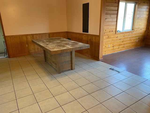 dining space with a sauna, wood walls, wainscoting, and light tile patterned floors