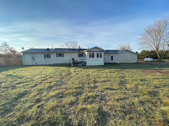 back of house featuring a yard and fence