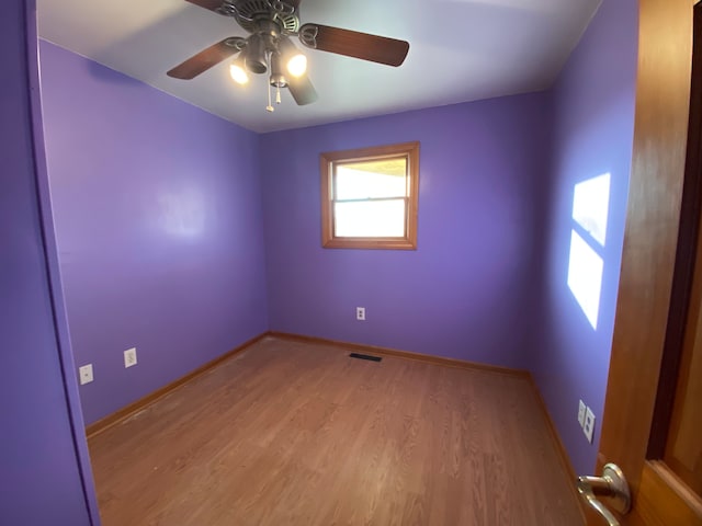 unfurnished room featuring visible vents, ceiling fan, baseboards, and wood finished floors