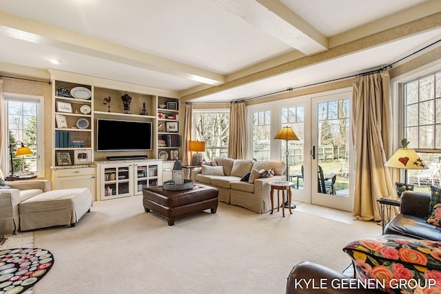 living area with beam ceiling, french doors, and carpet floors