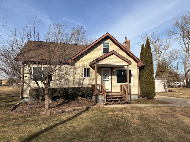 bungalow-style house featuring a front lawn and a chimney