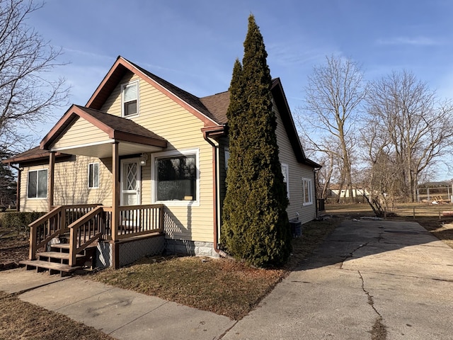 view of front of property featuring central AC and roof with shingles