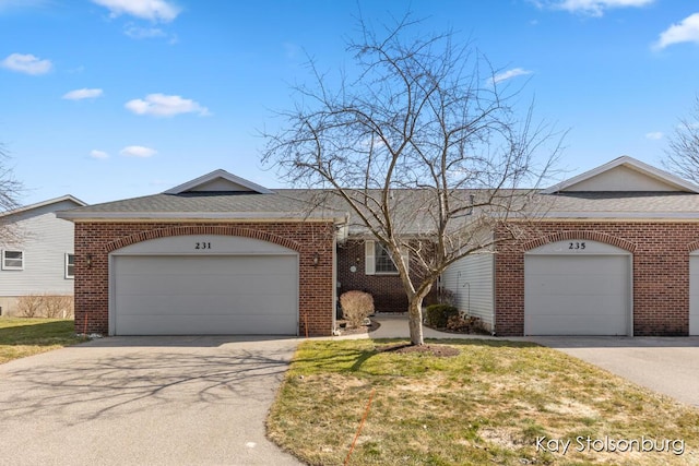 single story home with brick siding, an attached garage, and driveway