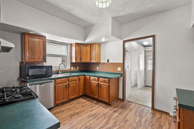 kitchen with a sink, brown cabinets, dishwasher, and black microwave