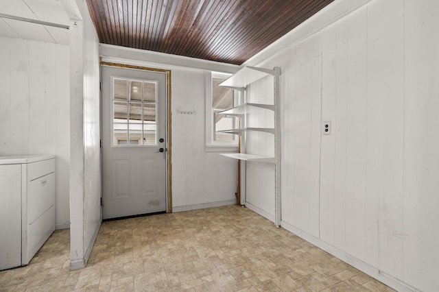 interior space featuring wood walls, wooden ceiling, and washer / clothes dryer