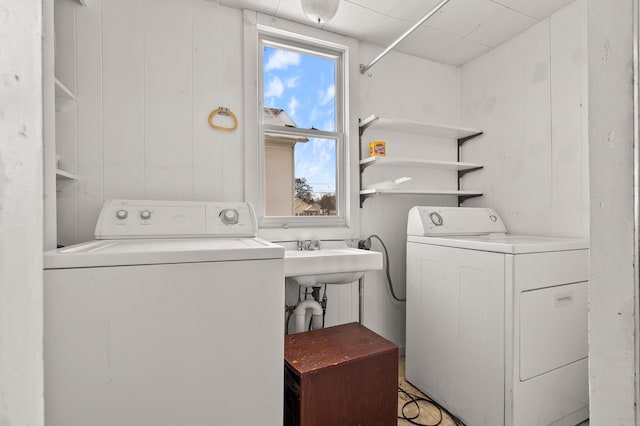 clothes washing area with laundry area, washing machine and dryer, and a sink