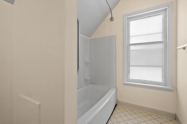 full bathroom featuring baseboards, lofted ceiling, and  shower combination