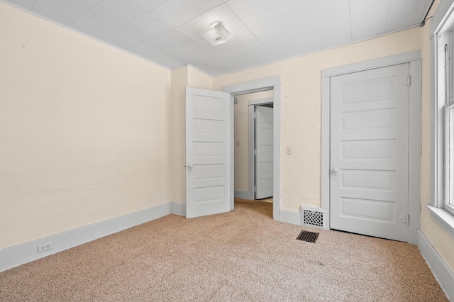 unfurnished bedroom featuring visible vents, baseboards, and carpet