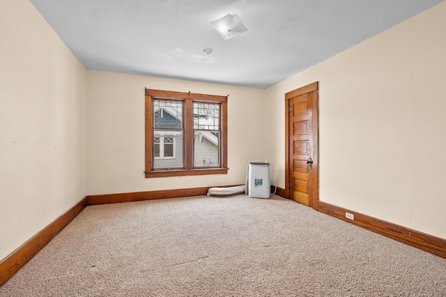 unfurnished room featuring carpet flooring and baseboards