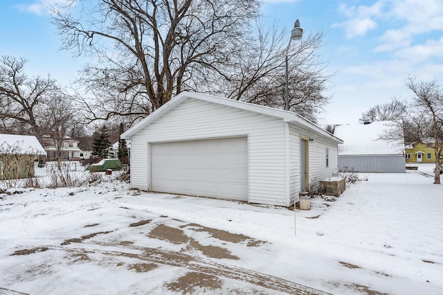 snow covered garage featuring a detached garage