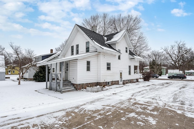 view of snowy exterior featuring a chimney