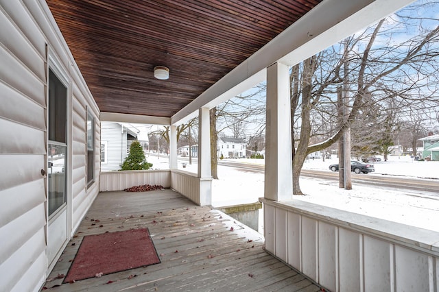 snow covered deck featuring a porch