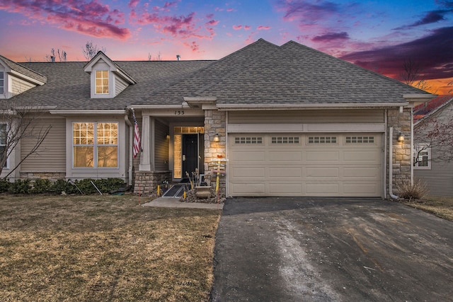 view of front of property featuring aphalt driveway, a garage, stone siding, and roof with shingles