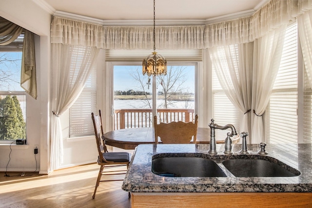 interior space featuring baseboards, wood finished floors, an inviting chandelier, and ornamental molding